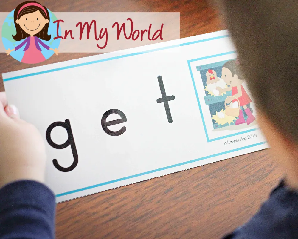 Child using a CVC word slider card to sound out and read the word “get,” practicing blending and decoding skills. Free printables available on the blog.