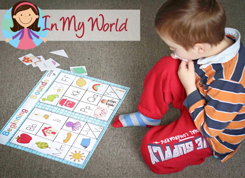 Child playing a beginning sounds file folder game to match pictures with their starting sounds, focusing on the letter G. Free printable available on the blog.