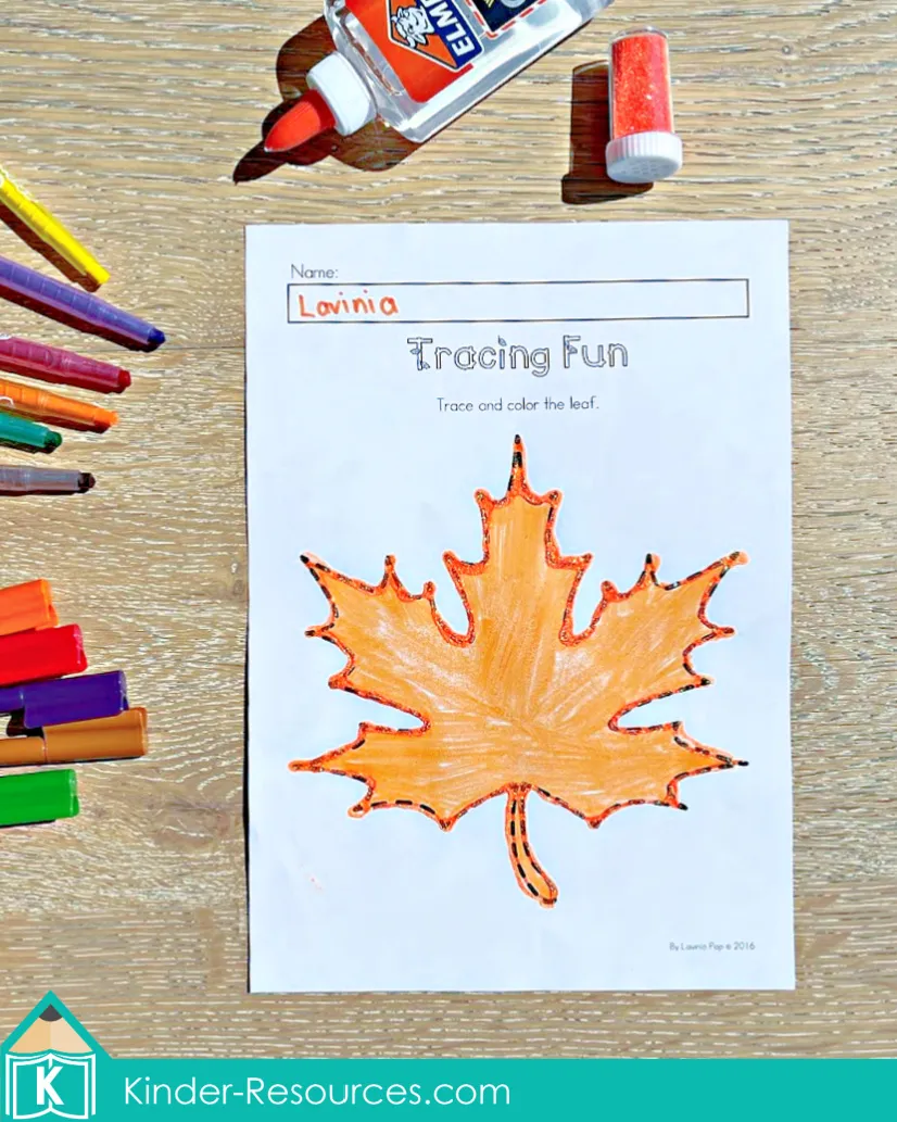 Preschool autumn tracing worksheet with a large maple leaf to trace and color for fine motor and pre-writing practice.