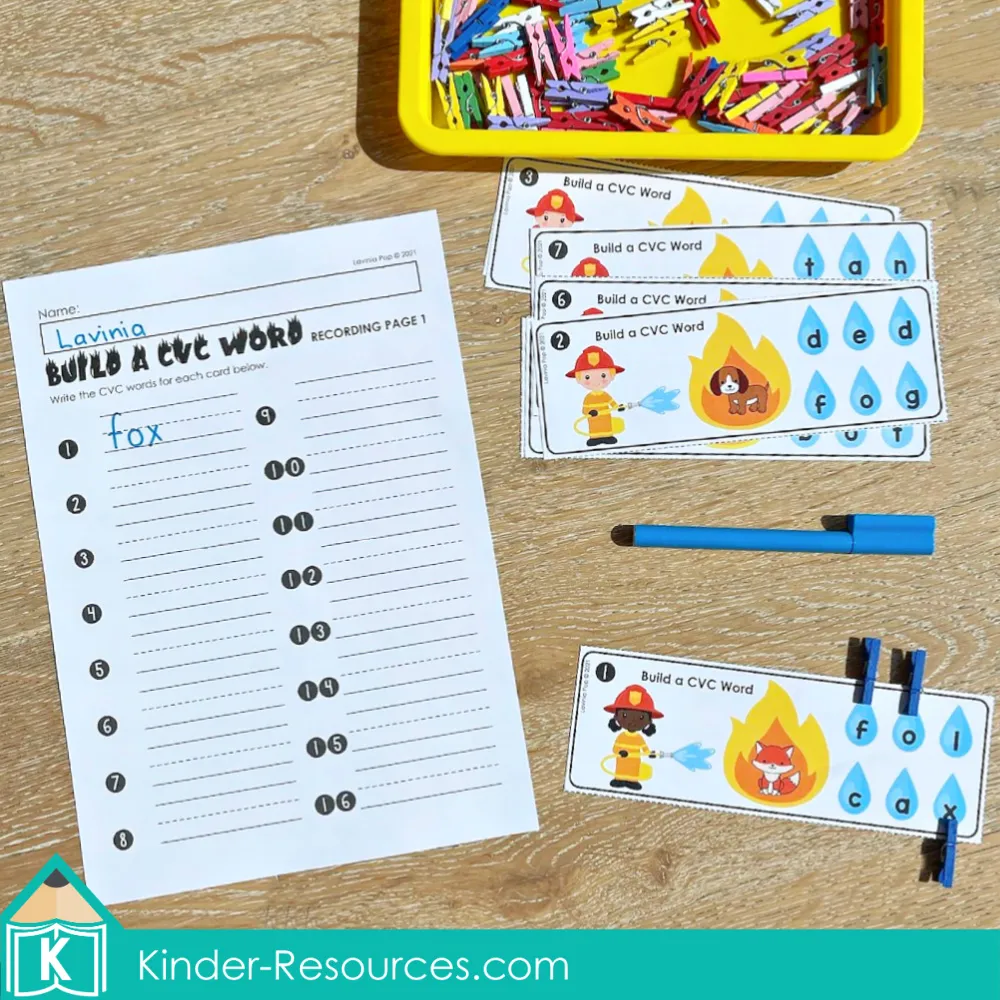 Kindergarten fire safety literacy center activity where children build CVC words with letters and record answers on worksheets