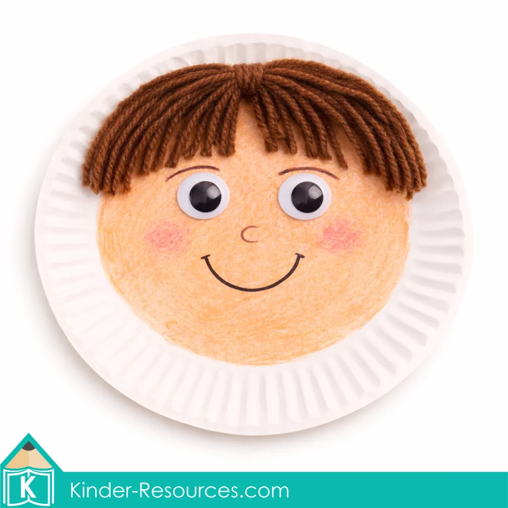 God Made People boy paper plate craft with drawn facial features and yarn hair used in a preschool Bible lesson