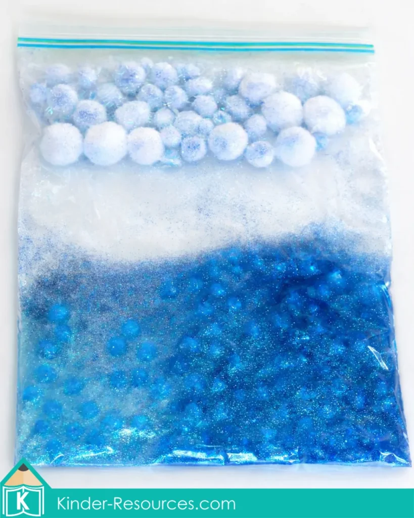 Preschool Bible Lesson God Made the Sky sensory bag with water beads below and cloud pom poms above
