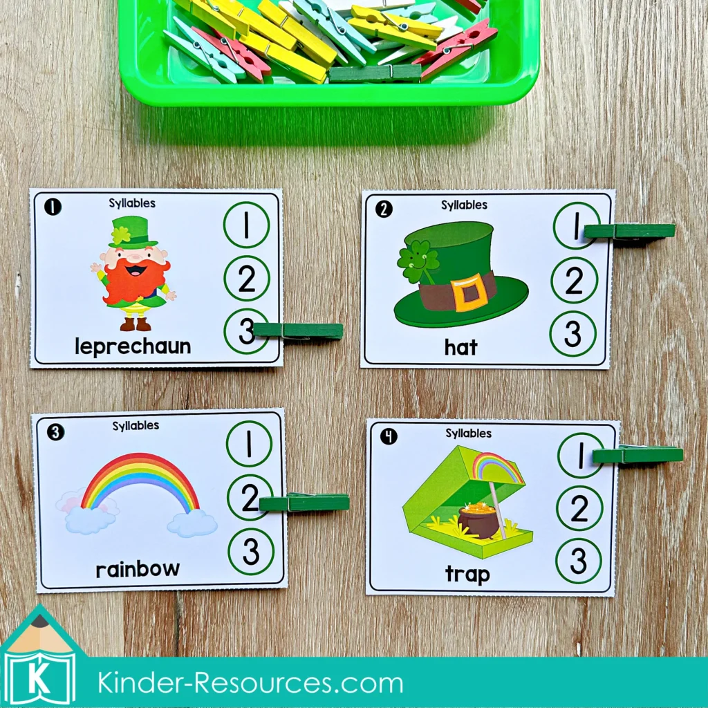 St. Patrick’s Day Literacy Centers for Kindergarten March Morning Tubs syllable clip cards with leprechaun, hat, rainbow, and trap using clothespins for phonemic awareness.