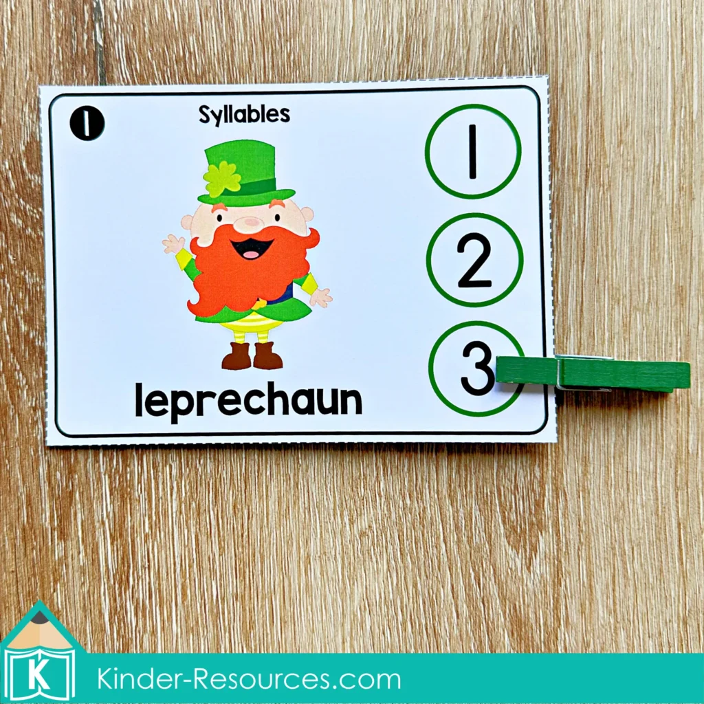 St. Patrick’s Day Literacy Centers for Kindergarten March Morning Tubs syllable clip cards with leprechaun, hat, rainbow, and trap using clothespins for phonemic awareness.