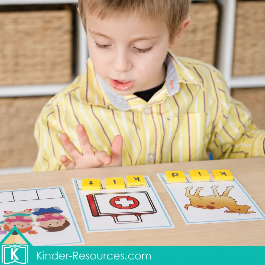 Child using yellow letter tiles to build kit and kid on picture mats during a preschool letter K phonics activity.