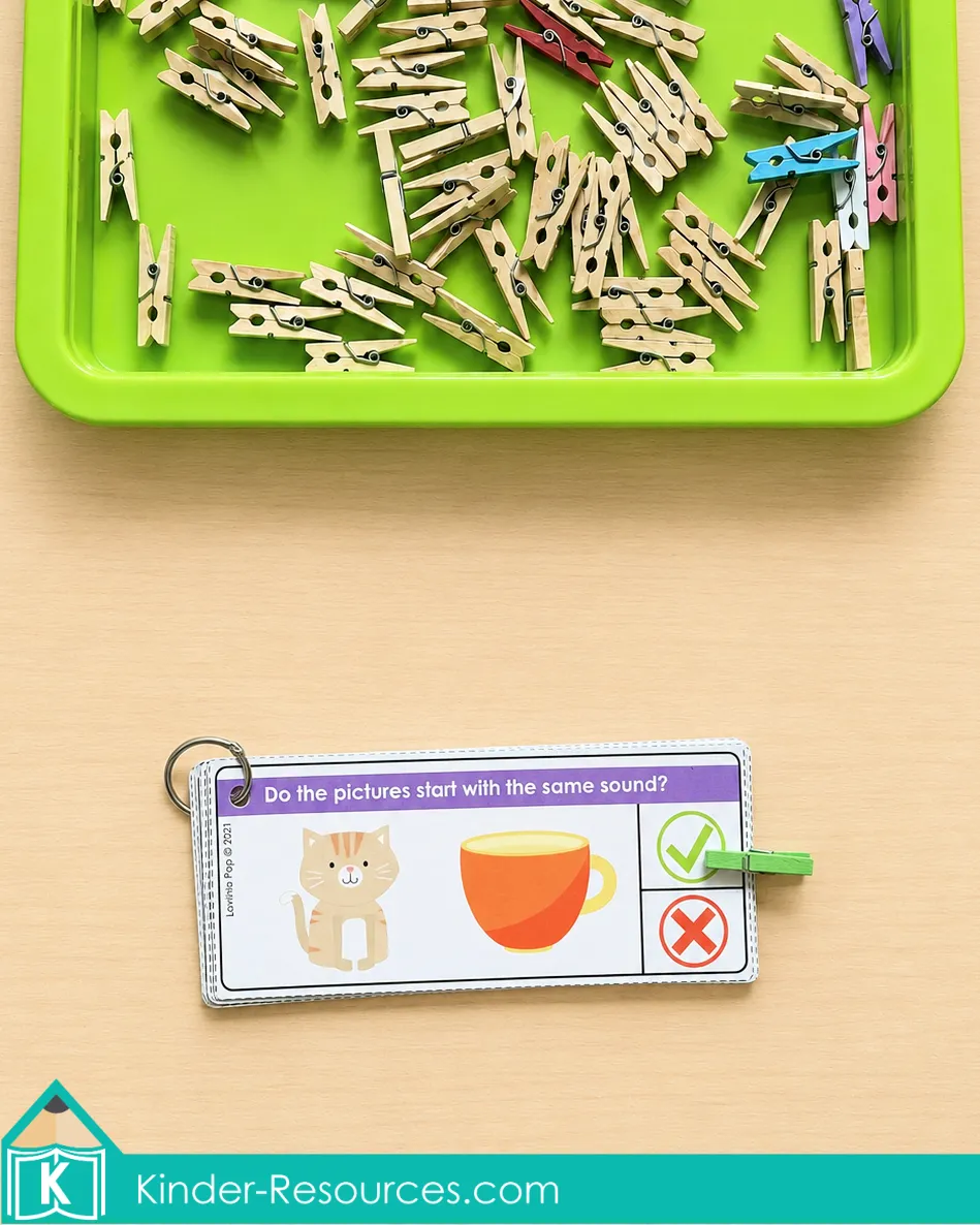 Using beginning sounds clip cards to determine whether cat and cup begin with the same sound.