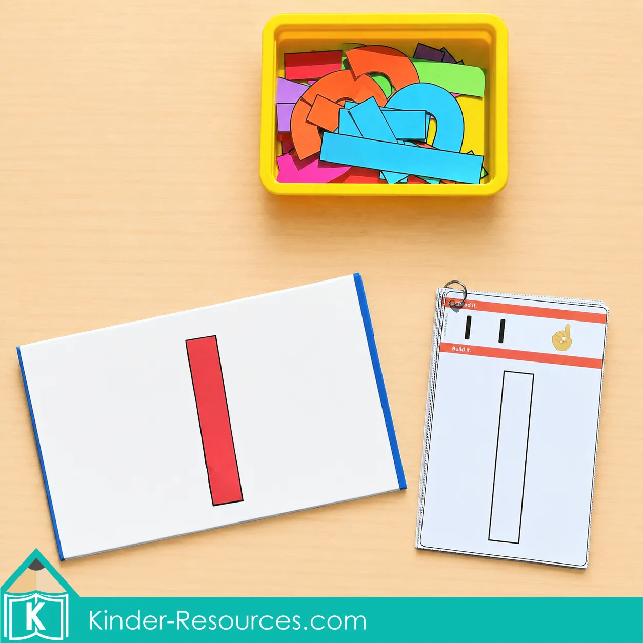 Using a red printable piece on a whiteboard beside an outlined number 1 card and a yellow tub of letter pieces.