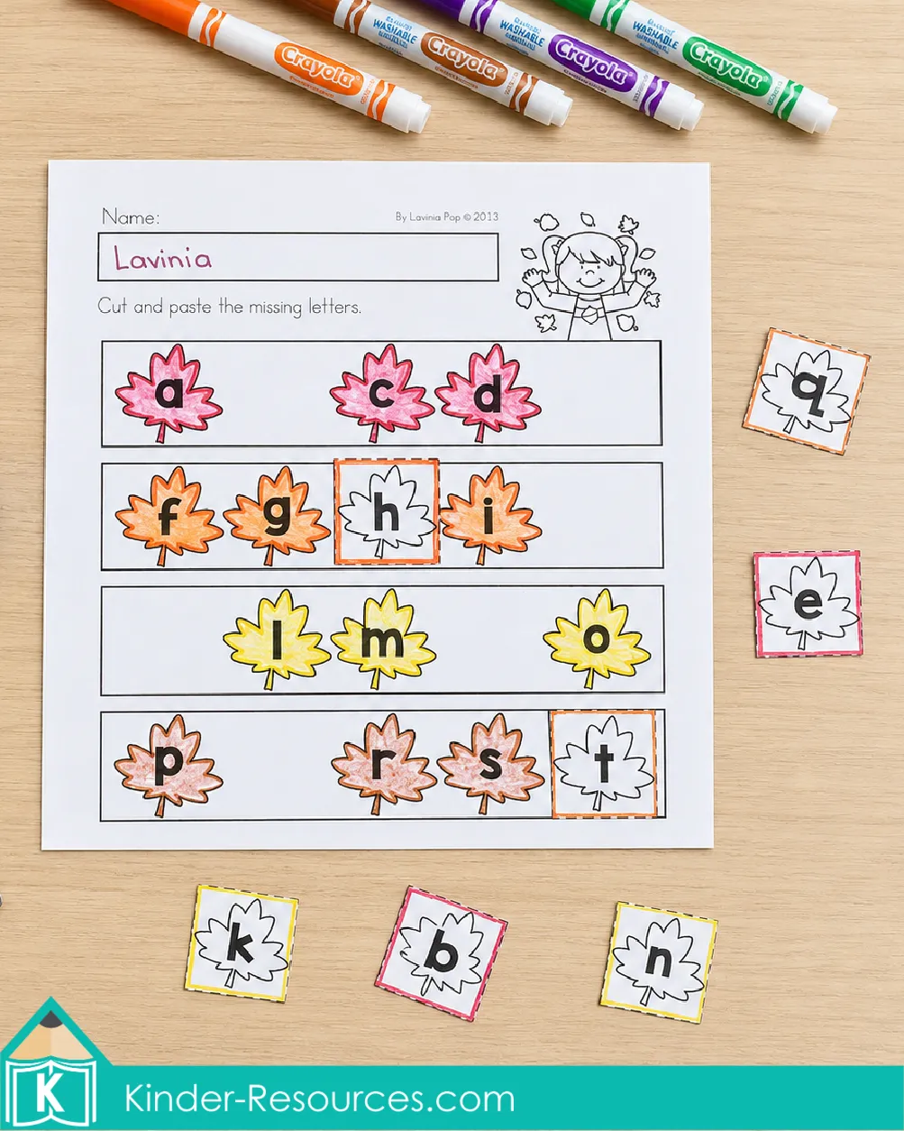 Cutting and pasting missing lowercase letters into alphabet sequences on an autumn literacy worksheet for kindergarten.