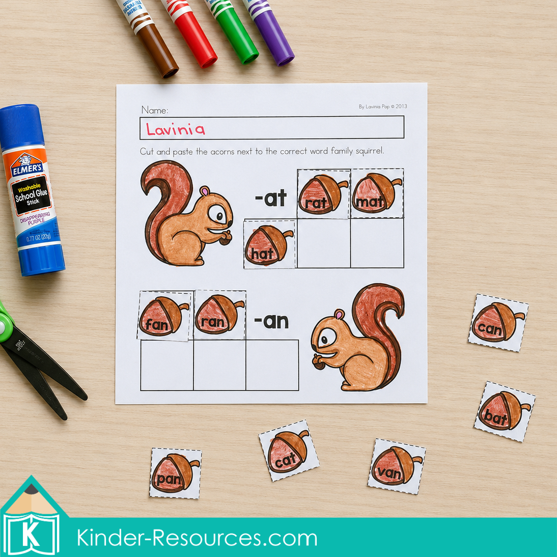 Cutting and pasting short a word family acorns into the matching -at and -an groups on an autumn literacy worksheet for kindergarten.