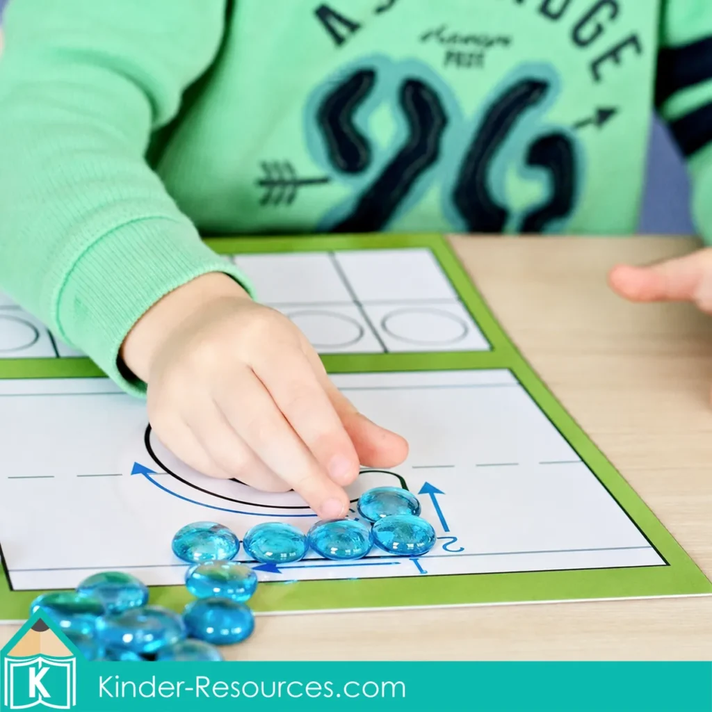 Child placing translucent blue glass gems along the numeral 5 formation path during a preschool number 5 fine motor activity.