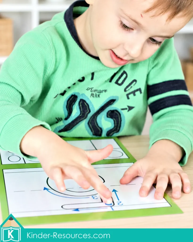 Child finger tracing the numeral 5 formation path on a laminated preschool number 5 mat with directional arrows and a ten frame.