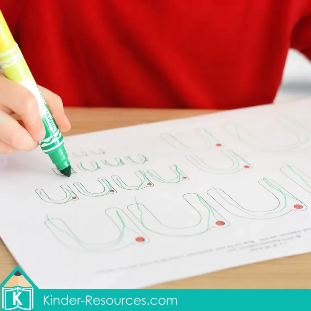 Preschool child tracing lowercase letter n formation paths with a green marker on a handwriting worksheet.