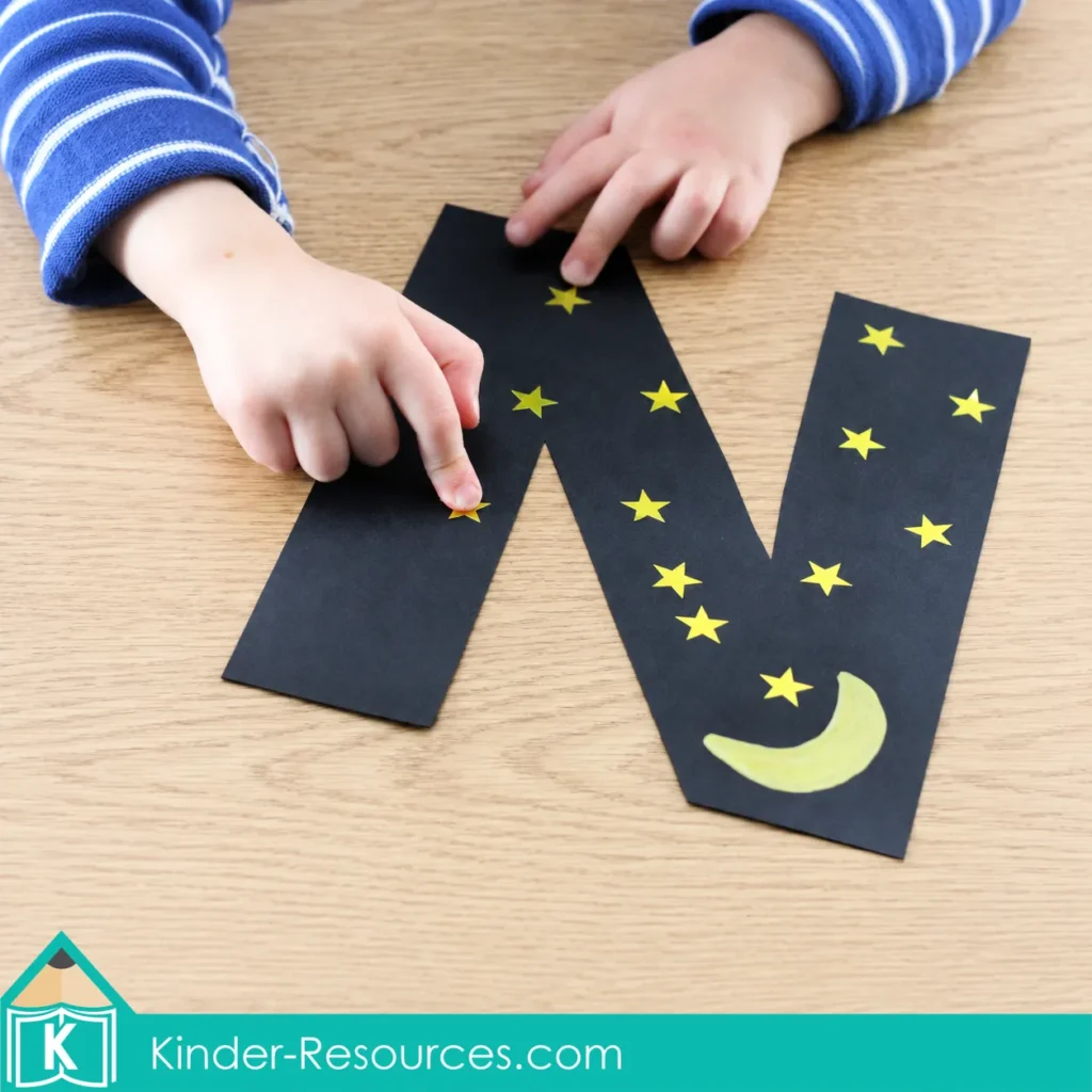 Preschool Letter N night-sky craft made with black paper, yellow stars and a crescent moon.