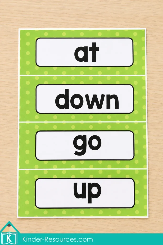 Printable sight word cards for at, down, go and up with green polka dot borders for kindergarten word walls and pocket charts.