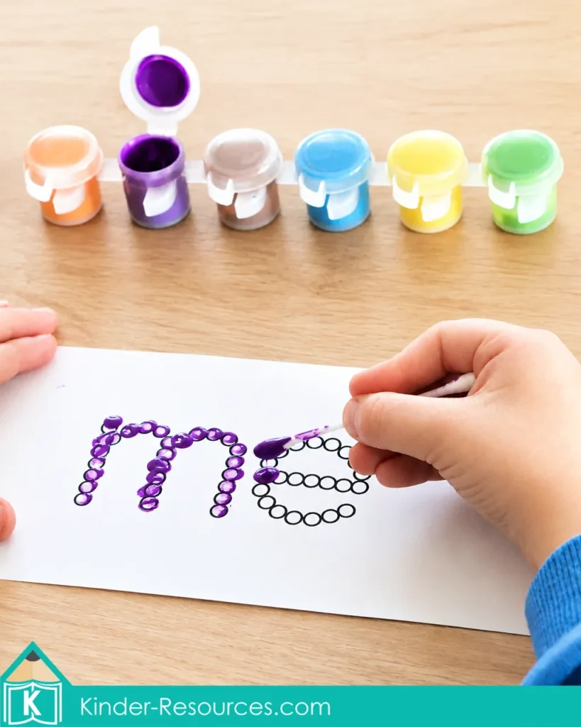 Using a Q-tip and purple paint to dot the sight word me on a printable kindergarten fine motor activity.