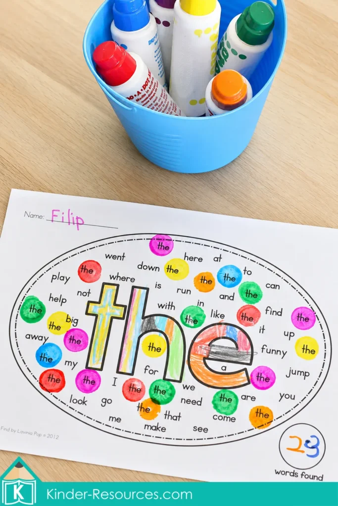 Completed pre primer sight word word find worksheet for “the” beside a blue tub filled with colorful dot markers.