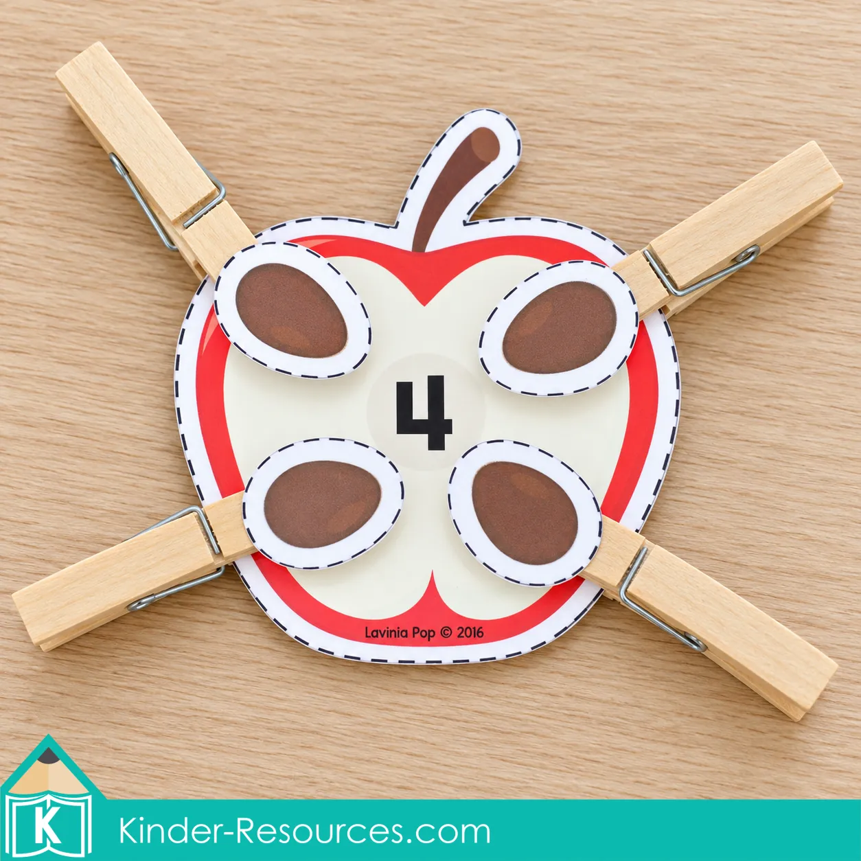 Number 4 apple counting activity for fall preschool centers with four seed pieces attached to wooden clothespins.