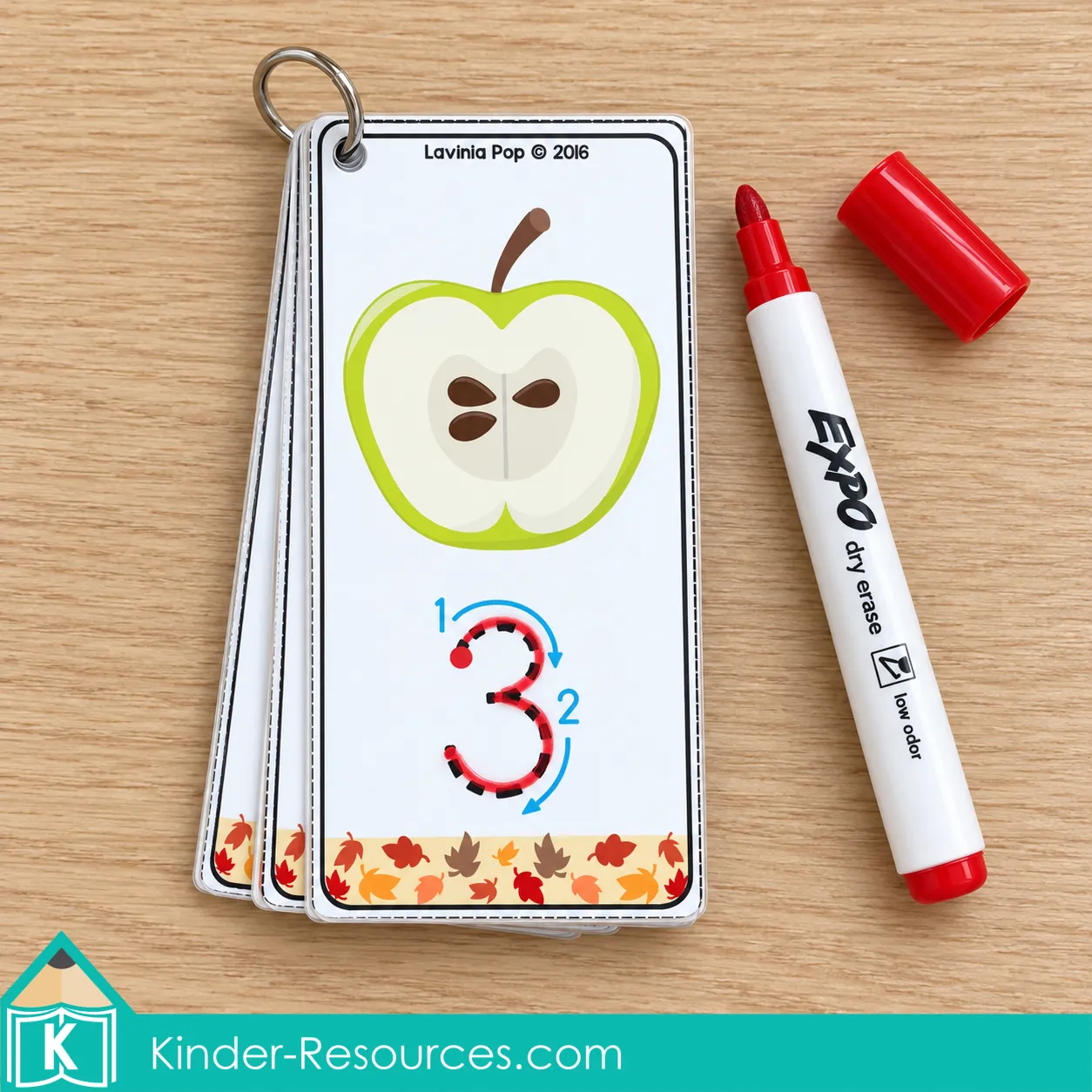 Apple number tracing cards for fall preschool centers on a binder ring, with the numeral 3 traced in red beside a dry-erase marker.