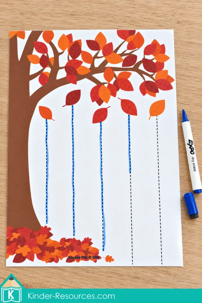 Falling leaves pre-writing page for fall preschool centers with vertical dotted lines, several traced in blue.