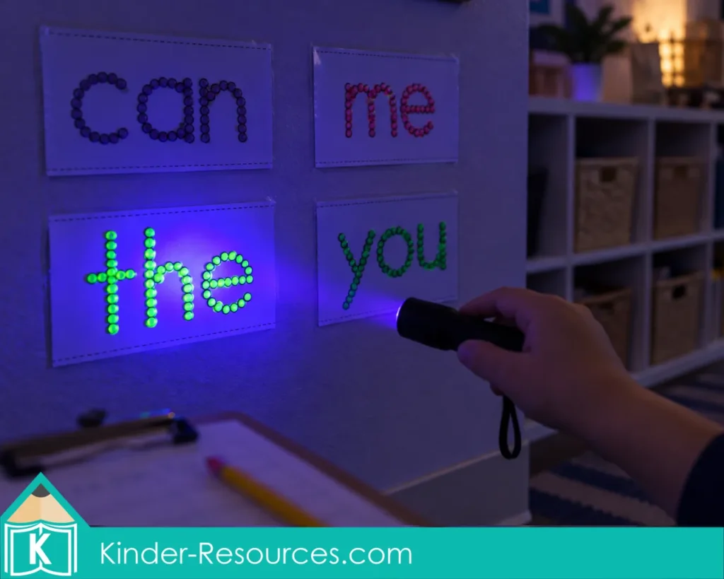 Child using a blacklight to find glowing sight word cards displayed on a classroom wall
